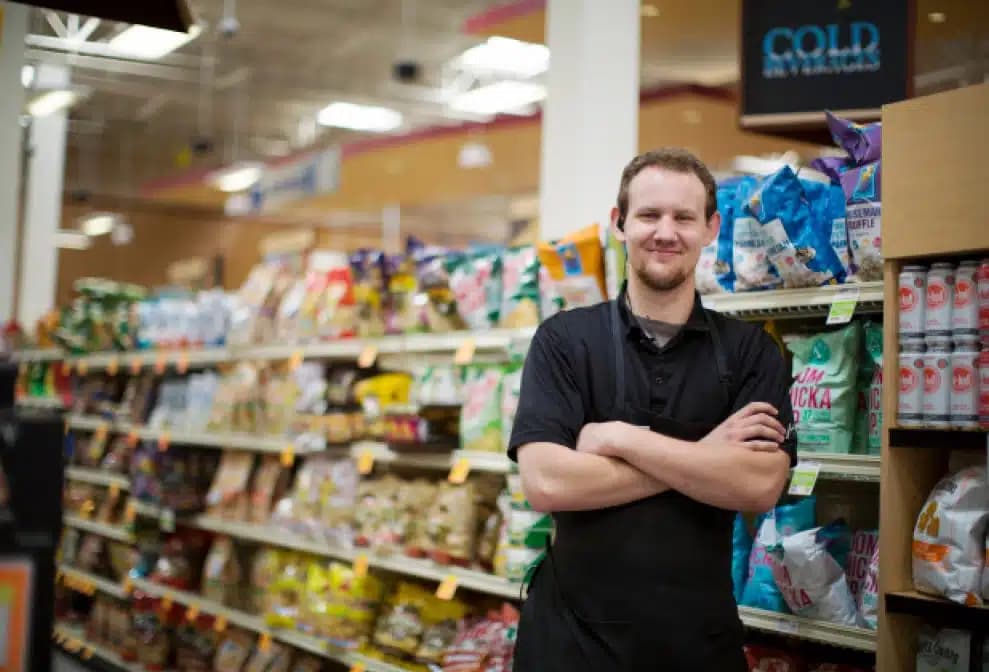 Harmons associate standing in a grocery aisle