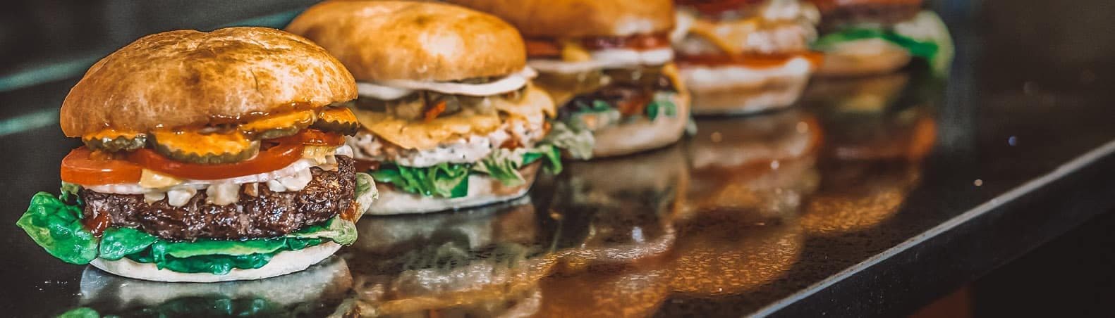 A row of freshly built Just Burgers lined up on a counter